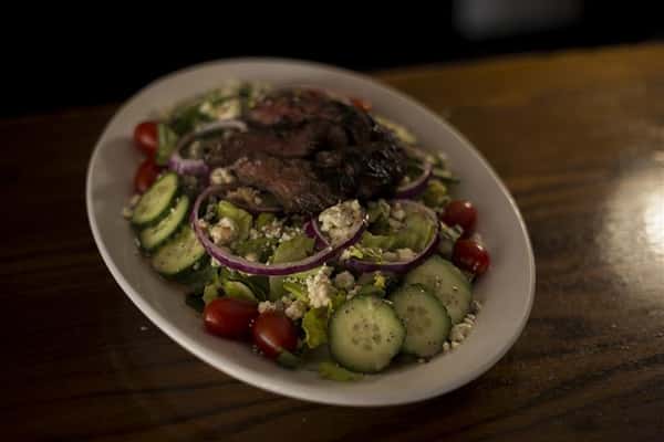 Donovan's Special salad, chopped romaine, with grilled hanger steak, red onions, tomato, blue cheese crumbles & roasted garlic red wine vinaigrette.