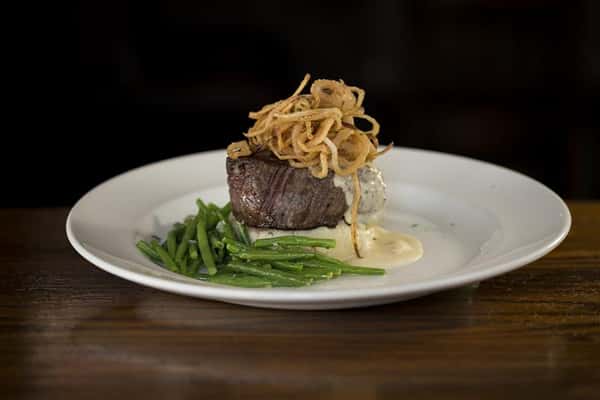8oz. Beef tenderloin topped with black peppercorn boursin cheese cream sauce and haystack onions over red skin mashed potatoes.