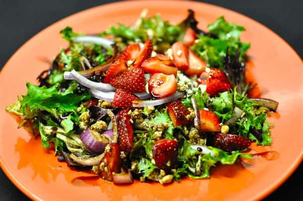 Salad with strawberries, red onion and a vinaigrette dressing.