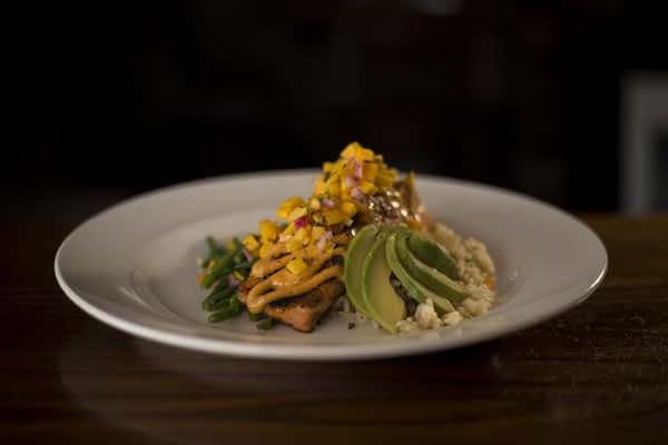 Blackened Grilled Salmon topped with avocado, mango salsa and lemon chipotle aioli served with rice pilaf.