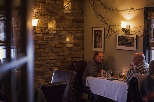 Two customers sitting at a table against the wall in the back of the restaurant.