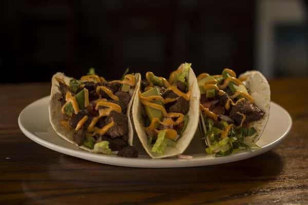 Three Steak House Tacos. Seasoned steak tips with a chipotle aioli, pico de gallo & avocado.