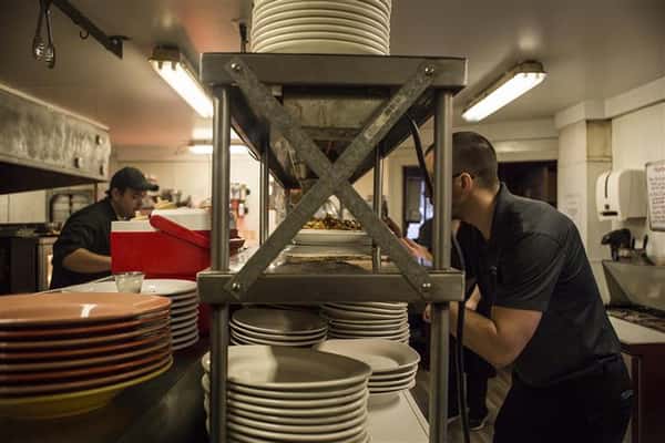 Staff members in the kitchen gathering table orders.