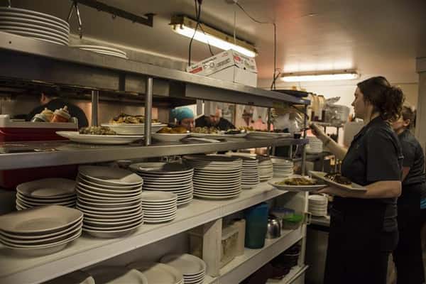 Staff members in the kitchen gathering table orders.
