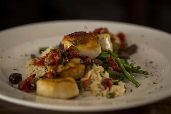 Pan Seared Scallops with sundried tomatoes, garlic, capers, basil and kalamata olives served with rice pilaf.