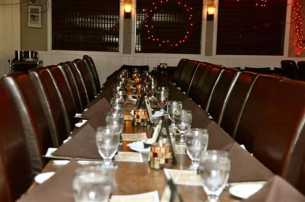 Empty large rectangular table set with glasses and napkins.