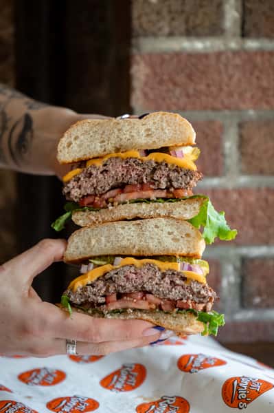 Hands holding split burger up to viewer