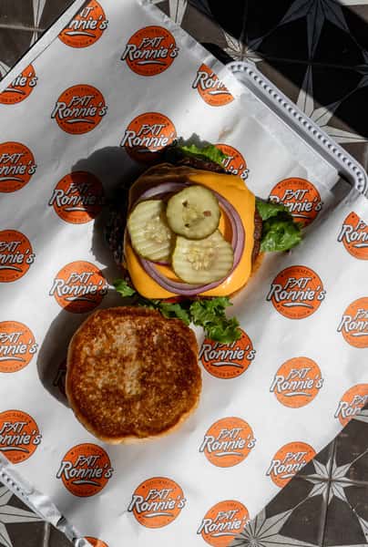 Cheeseburger with onion rings on branded paper