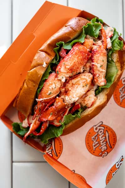 Lobster roll served in an orange takeout tray