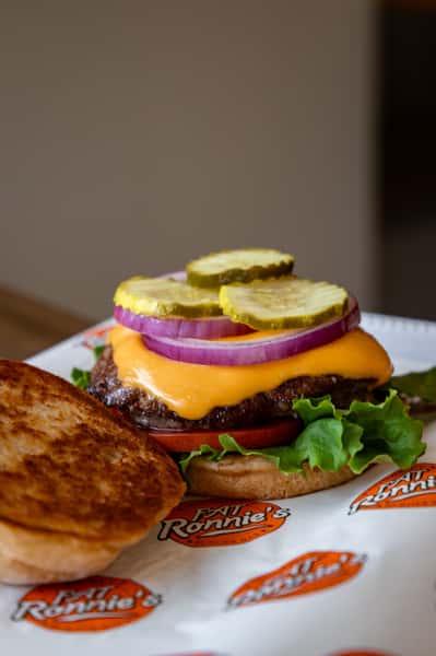 Cheeseburger with melted cheese served alongside onion rings