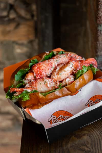 Close-up of a lobster roll overflowing with seasoned lobster