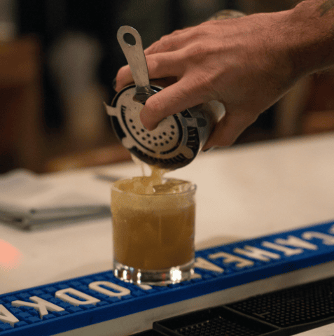 bartender straining a cocktail