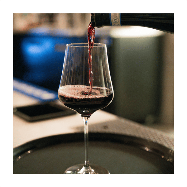 glass of red wine being poured