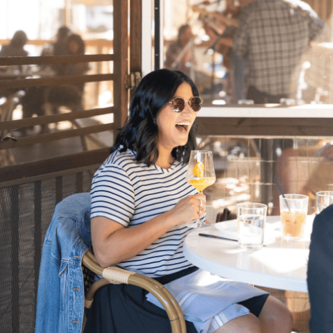 person laughing and drinking outside