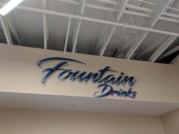 Fountain drinks sign on wall inside market