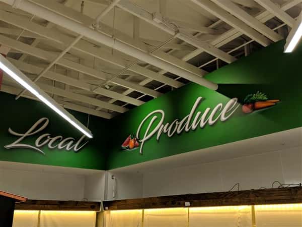 Local produce sign on wall inside market