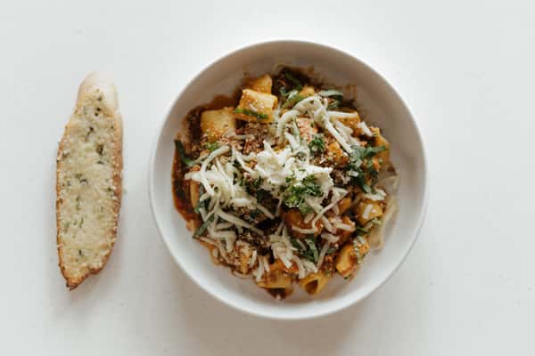 Gourmet shrimp risotto topped with fresh basil, herbs, and balsamic drizzle in a white bowl
