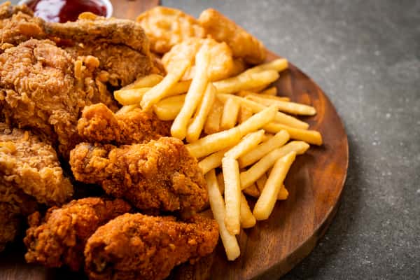 chicken tenders and fries on wooden board