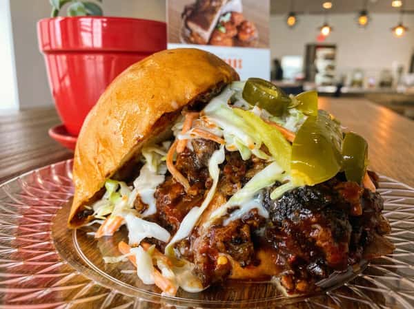 Smoked pulled pork sandwich with pickles and sauce at Fainmous BBQ in Pearland TX