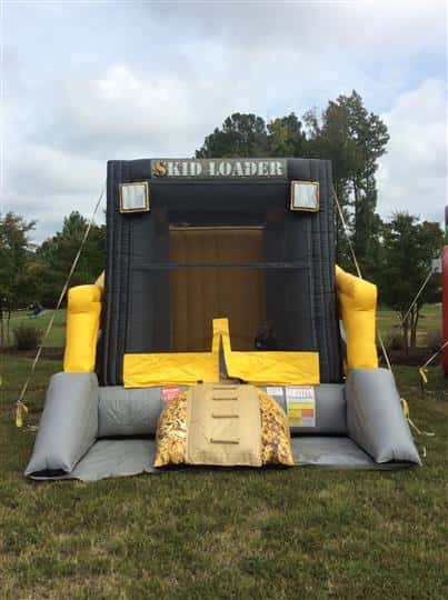 an inflatable bounce house that says "Skid Loader"