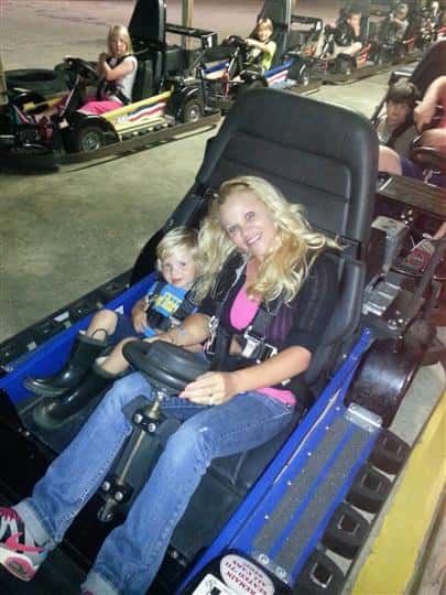 a mom and her son sitting in a go kart