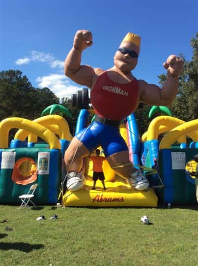 an inflatable obstacle course with an inflatable man wearing a top that says "Iron man"