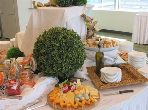 Detail of a buffet table set in linen with a variety of platters with snacks and finger food