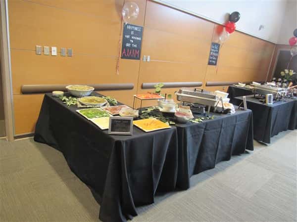 Buffet tables covered in linen with a variety of platters and catering equipment ready for service