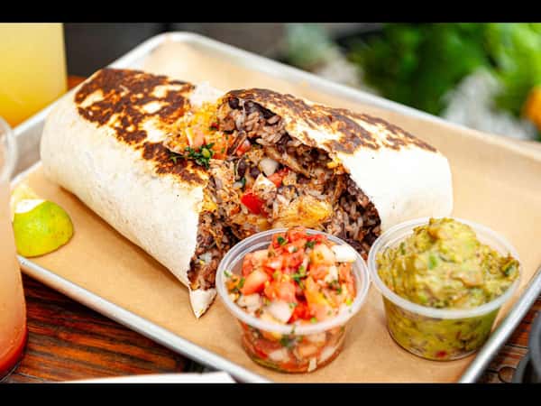 Large grilled Burrito Famous burrito stuffed with seasoned meat, rice, beans, and fresh toppings, served with house-made guacamole, pico de gallo, and a lime wedge.
