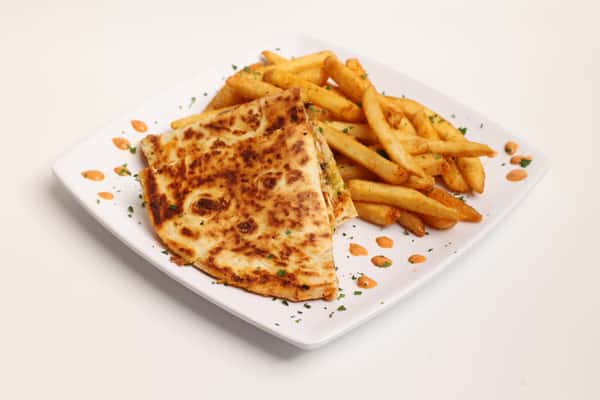 Fries and a quesadilla are plated on a white dish, garnished with seasonings. The image can be found in a gallery of food images on the website.