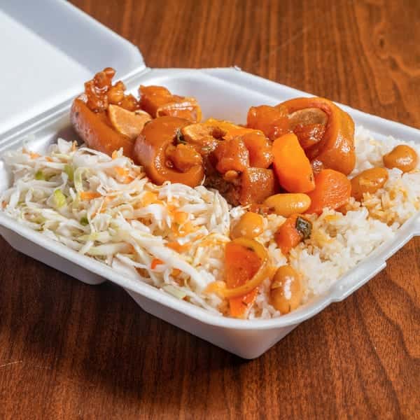 Saucy shrimp served over rice with a side of coleslaw