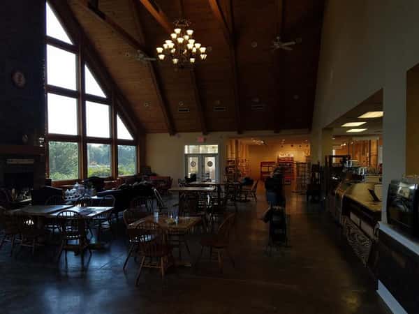 The Peanut Man dining area. Wood chairs and tables in front of large windows, under high ceilings