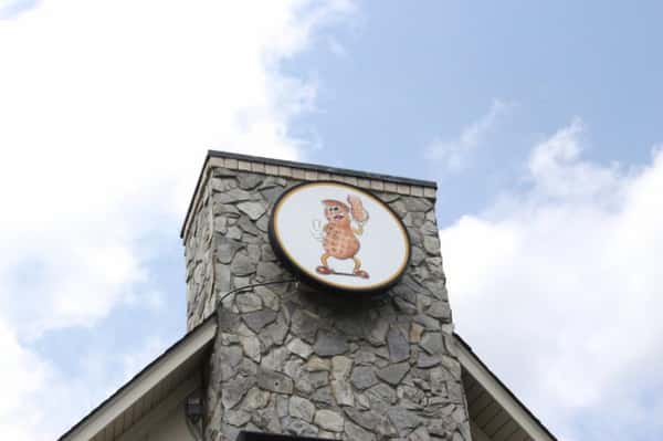 The Peanut Man sign atop chimney structure on exterior of building.