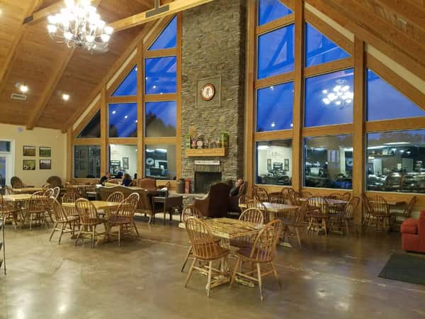 The Peanut Man dining area. Wood chairs and tables in front of large windows, under high ceilings