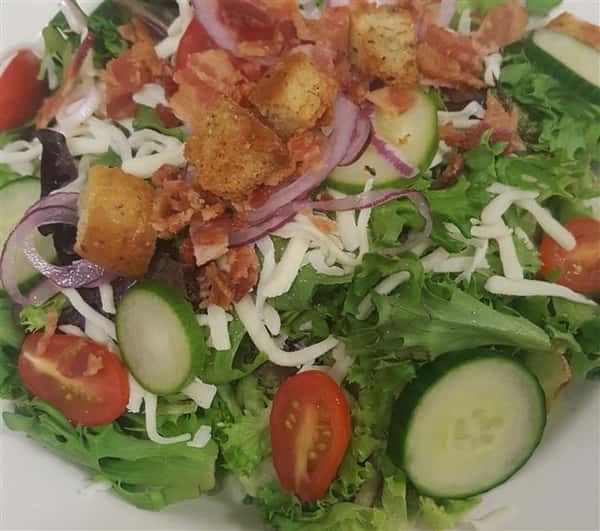 House salad with mixed greens, grape tomatoes, cucumbers, croutons, red onion, bacon, shredded cheddar jack cheese.