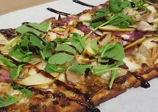 Giovanni Italian Flatbread. House made marinara, prosciutto (italian ham), ham, salami, fresh mozzarella, green onion, and finished with our balsamic glaze.