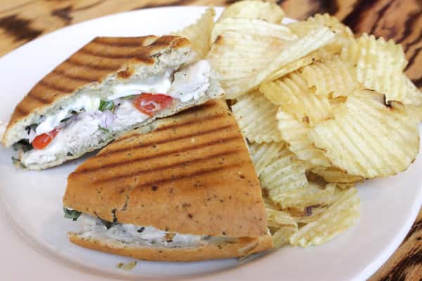 Flatbread sandwich with side of chips.