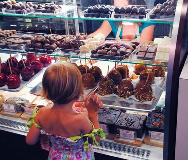 Young girl looking at candied apples in cold case