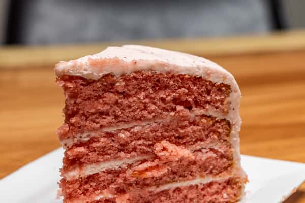 Close-up of a delicious slice of layered chocolate cake featuring moist chocolate sponge, rich creamy filling, and smooth frosting, freshly prepared for dessert.