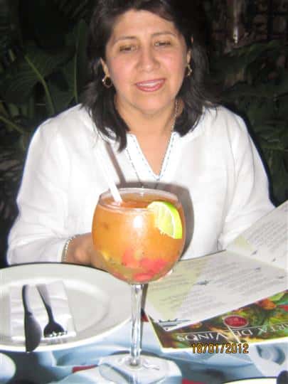 female sitting at table with menu and large drink