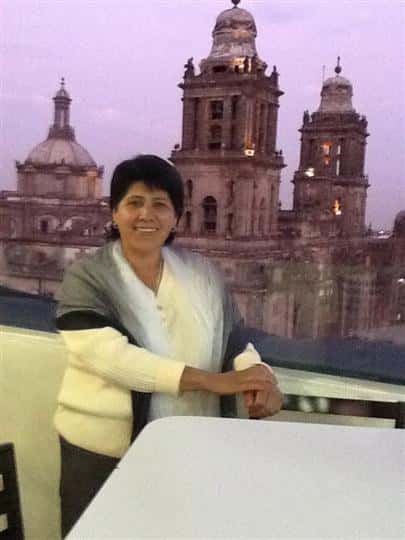 female posing for picture with buildings in the background