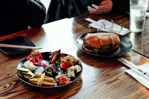 Assorted pickled vegetables with sliders on a wooden table