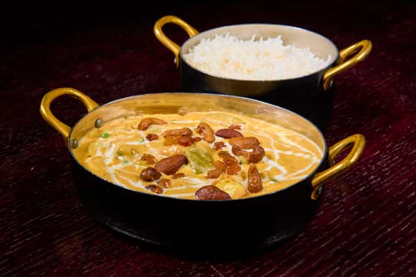 Paneer butter masala topped with cream and nuts served with basmati rice