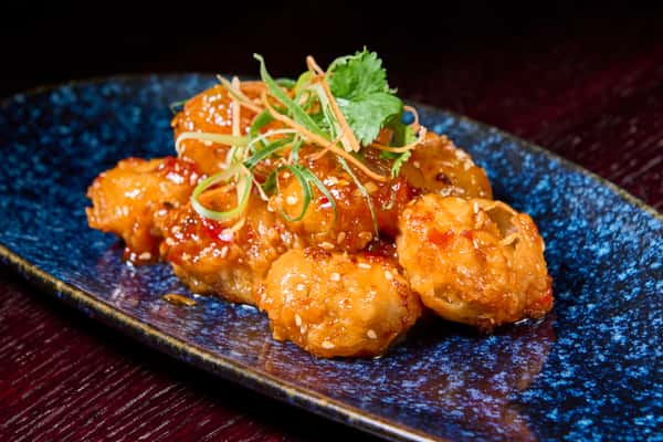 crispy fried shrimp tossed in sweet chili sauce topped with sesame seeds and fresh herbs