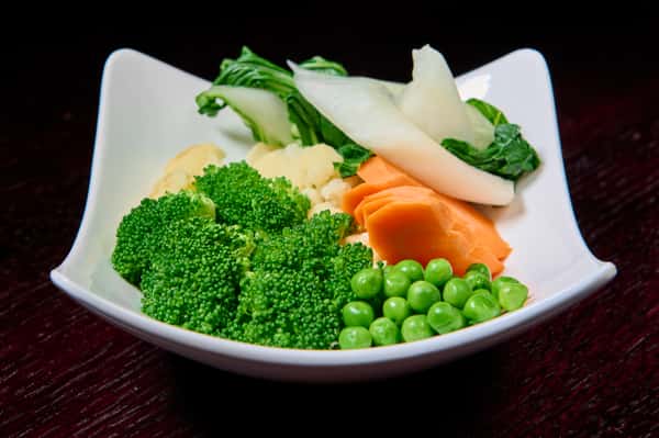 Steamed mixed vegetables including broccoli, carrots, peas, and bok choy