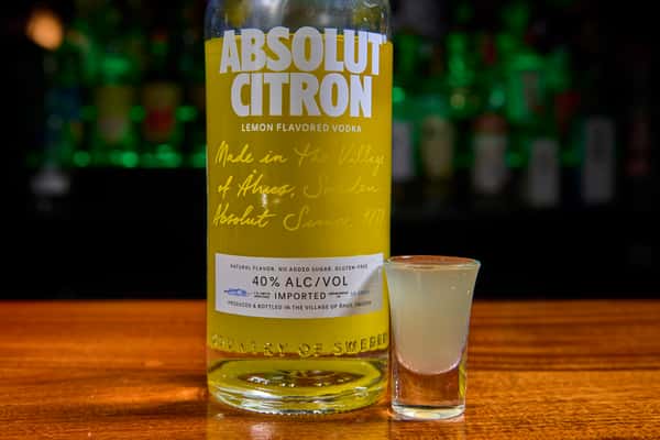 Absolut Citron vodka bottle with a chilled lemon vodka shot