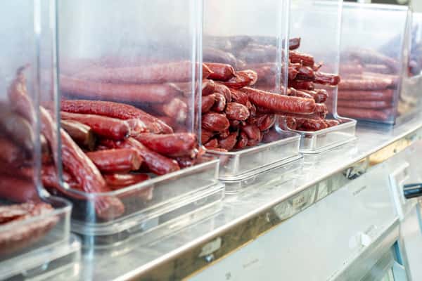rows of cured sausages stacked in deli display case inside G&W Sandwiches