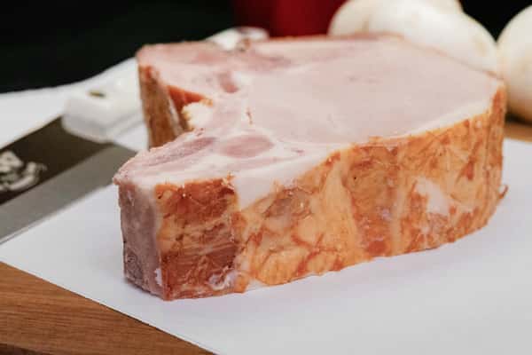 thick cut smoked pork chop showing bone and rich marbling on prep surface
