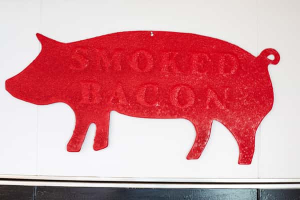 red pig shaped smoked bacon sign displayed on interior wall at G&W Sandwiches