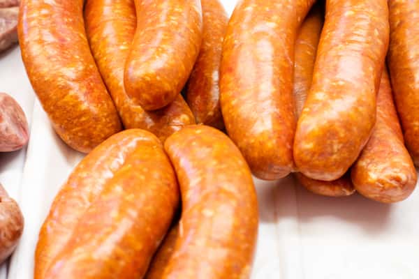 close-up of smoked sausages with glossy casing in deli display at G&W Sandwiches